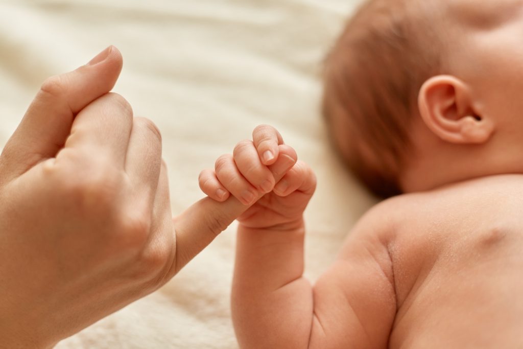 baby holding mothers finger